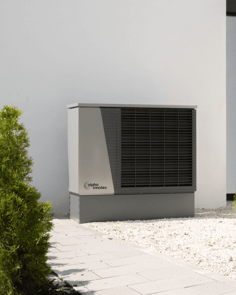 A modern air source heat pump installed outside a home